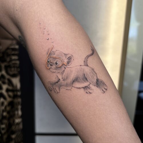 playful lion cub aviator goggles tattoo