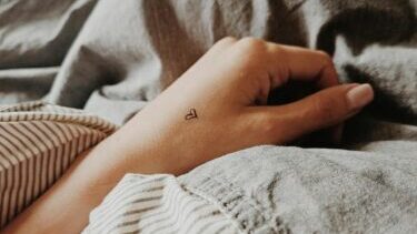 Hands of a Woman Wearing a Small Heart Tattoo